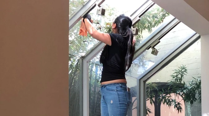 Woman cleaning glass window pre-sale cleaning